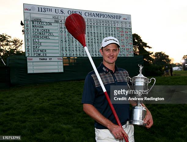 Justin Rose of England celebrates with the U.S. Open trophy while holding a wicker basket flagstick after winning the 113th U.S. Open at Merion Golf...