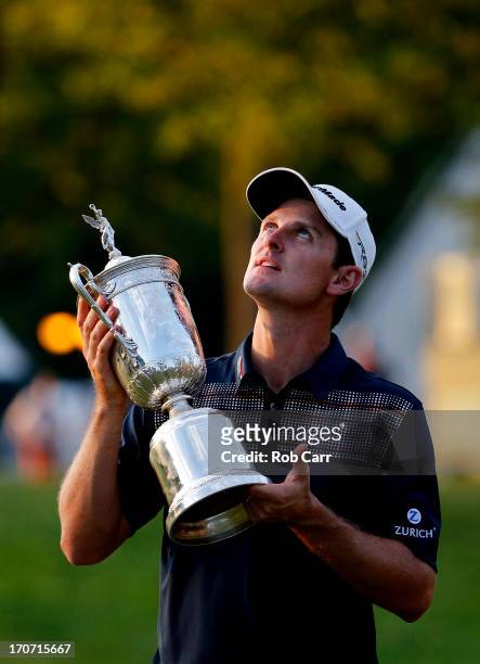 Justin Rose of England looks up as he celebrates with the U.S. Open trophy after winning the 113th U.S. Open at Merion Golf Club on June 16, 2013 in...
