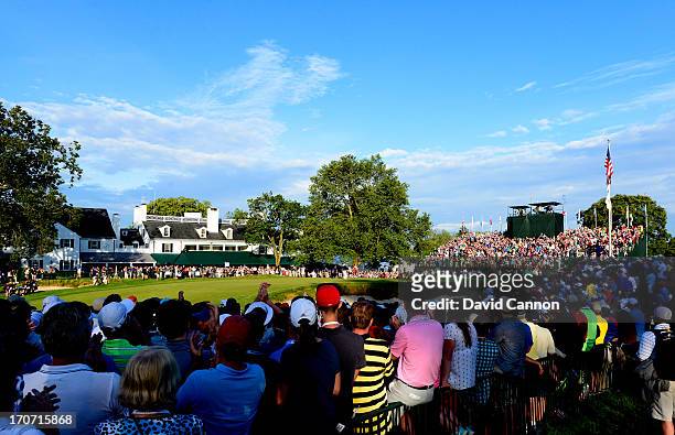 Fans watch play on the 18th green as Justin Rose of England reacts after putting on the 18th hole to complete the final round of the 113th U.S. Open...