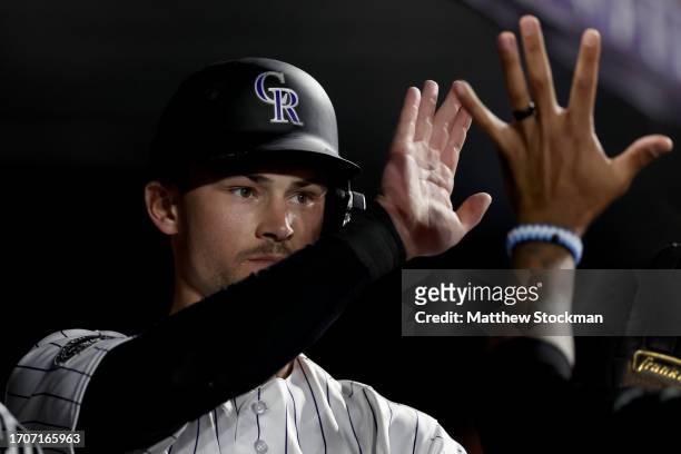 Brenton Doyle of the Colorado Rockies celebrates in the dugout after scoring on a Charlie Blackmon double against the Los Angeles Dodgers in the...