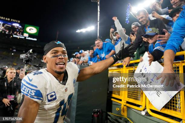 Amon-Ra St. Brown of the Detroit Lions celebrates with fans after defeating the Green Bay Packers in the game at Lambeau Field on September 28, 2023...