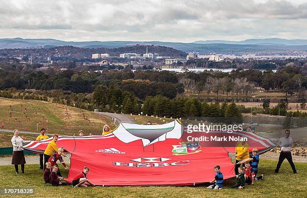 Centenary of Canberra Volunteers, National Arboretum volunteers and local rugby juniors hold the giant British & Irish Lions shirt at the National...