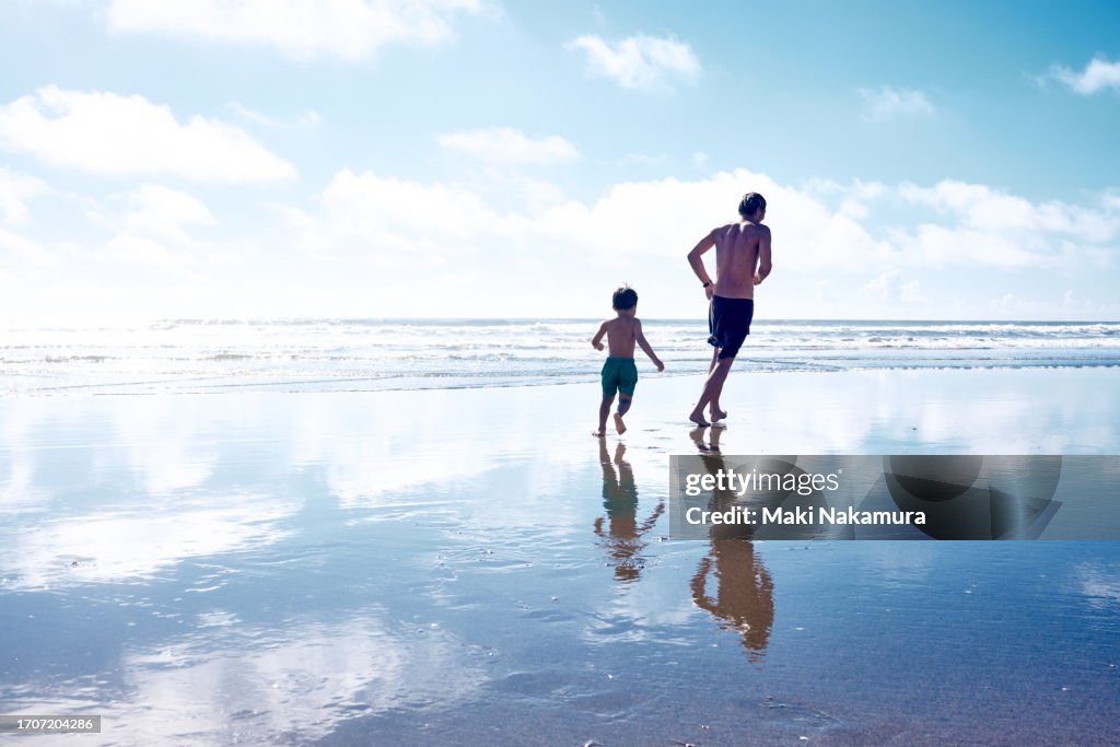Father and son playing chase in the sea.