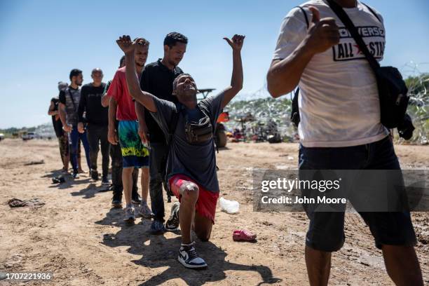 An immigrant from Venezuela prays after crossing the U.S.-Mexico border on September 28, 2023 in Eagle Pass, Texas. A surge of asylum seeking...