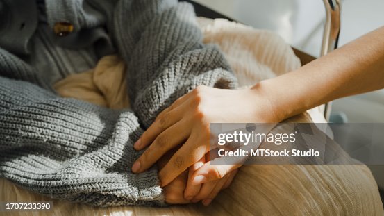 Closeup of young Asian people holding hands trust comfort help cancer patients talk crying stress relief in living room at home. Healthcare. Closeup of young Asian people holding hands trust comfort help cancer patients talk crying stress relief in living room at home. Healthcare.