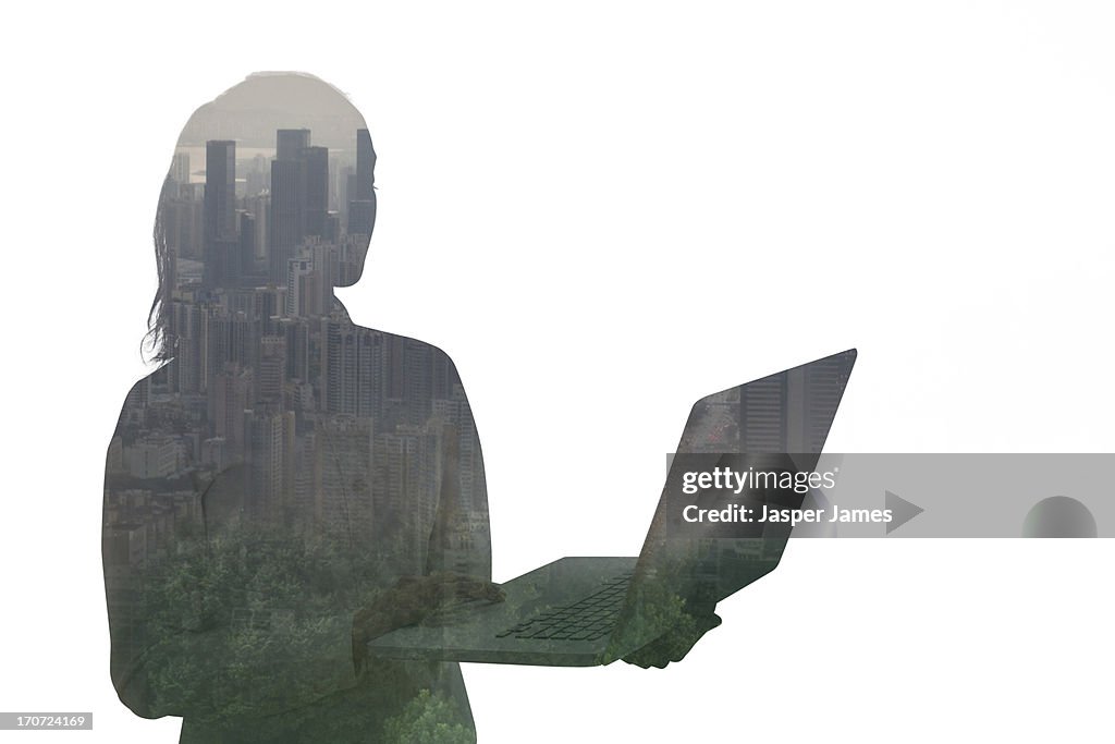 Composite of young woman using laptop and cityscap