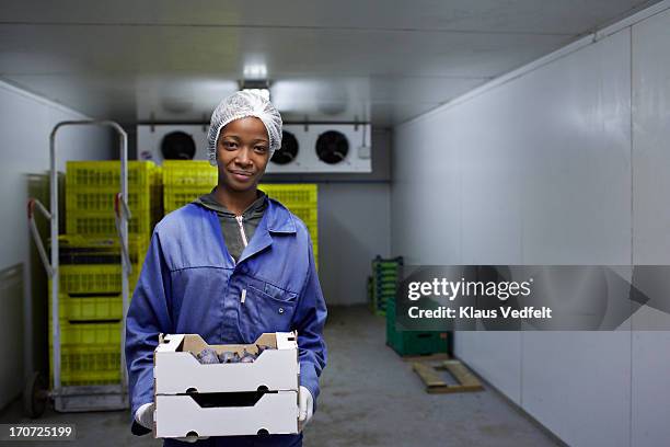smiling worker holding boxes of figs in cold room - hair net stock pictures, royalty-free photos & images