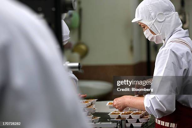 An employee fills polystyrene trays with steamed soybeans for making fermented soybeans, known as natto, at the Matsushita Shoten Y.K. Production...