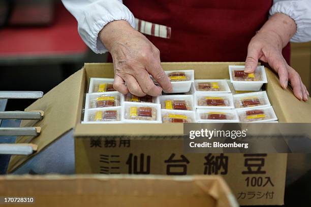 An employee packs sealed polystyrene trays of fermented soybeans, known as natto, into a box at the Matsushita Shoten Y.K. Production facility in...