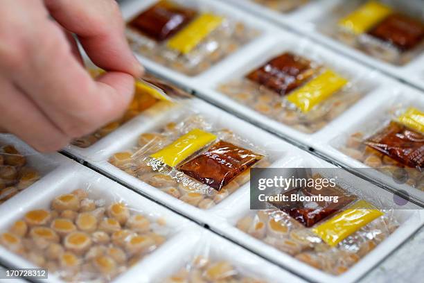 Sachets of seasoning sauce and mustard are arranged atop polystyrene trays of fermented soybeans, known as natto, at the Matsushita Shoten Y.K....