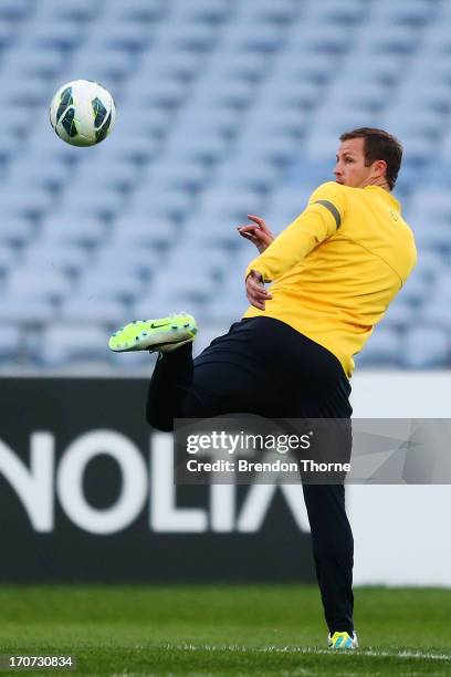 Lucas Neill of Australia kicks a ball during an Australian Socceroos training session at ANZ Stadium on June 17, 2013 in Sydney, Australia.