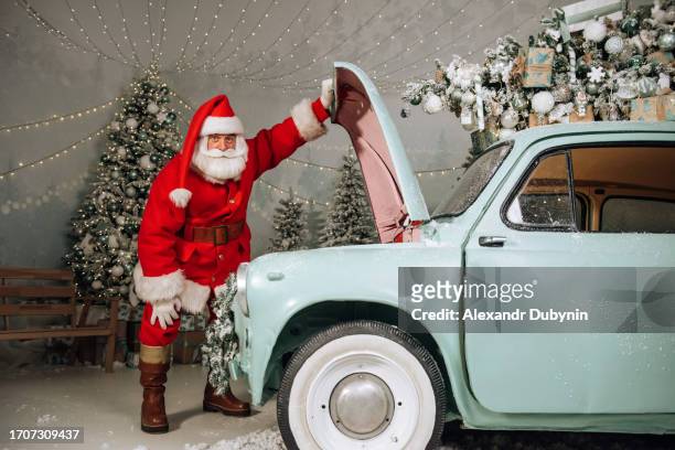 santa claus tries to fix a broken car - machine christmas tree stock pictures, royalty-free photos & images