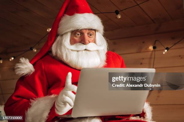 santa claus using laptop and internet to communicate - father christmas stock pictures, royalty-free photos & images