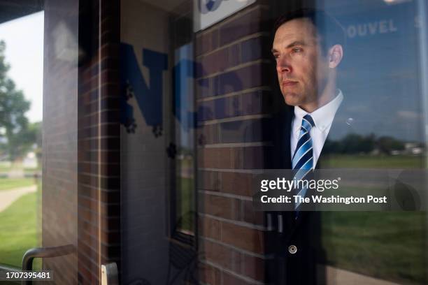 Cormac Lynn, Superintendent of Schools, Catholic Diocese of Saginaw through the glass of the door that was damaged after a fake SWAT call was made to...
