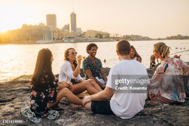 a group of friends do a weekly routine of hanging out by the sea, with a cold beer and the sound of a guitar - weekly stock pictures, royalty-free photos & images