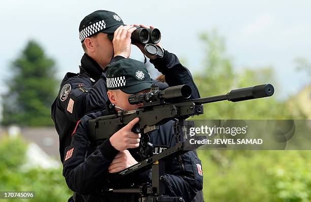 Police counter sniper armed units scan an area as US President Barack Obama and British Prime Minister David Cameron visit the Enniskillen Integrated...