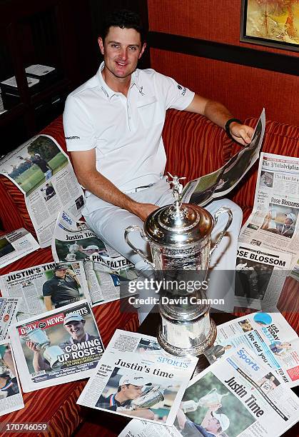 Justin Rose of England is surrounded by the morning papers as he reads the stories of his US Open win at Merion Golf Club at his hotel on June 17,...