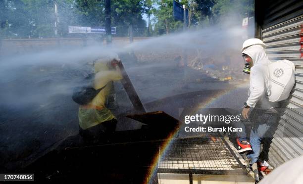 Anti-government protesters protect themselves from water cannon fired by police in the Kurtulus district on June 16, 2013 in Istanbul, Turkey....