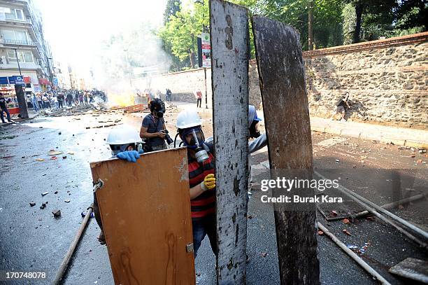 Anti-government protesters stand stand behind barricades in readiness to protect himself from water cannon used by police in Kurtulus district on...