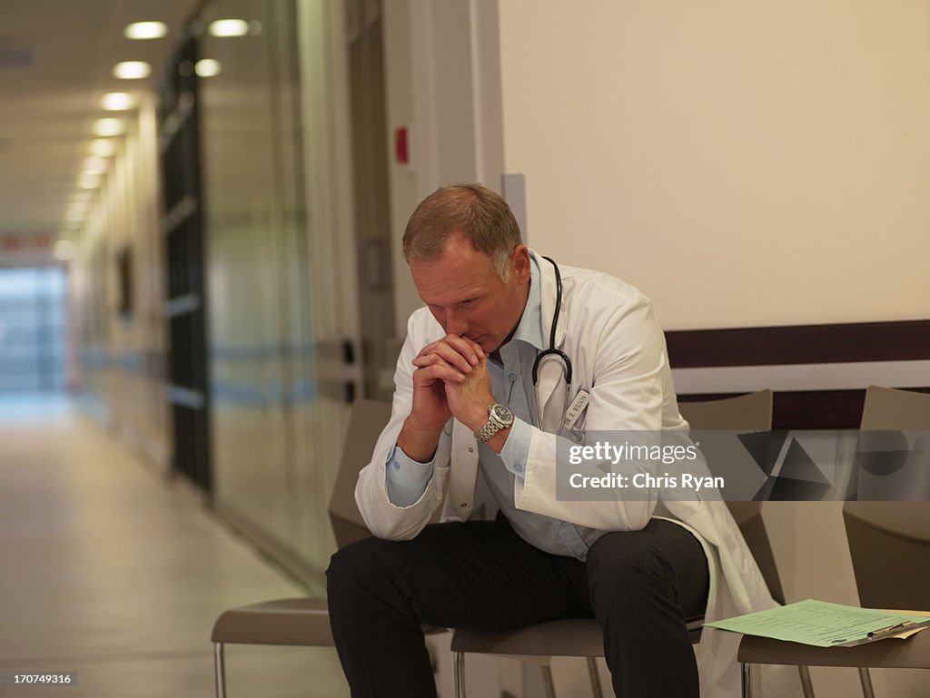 Frustrated doctor sitting in hospital waiting area