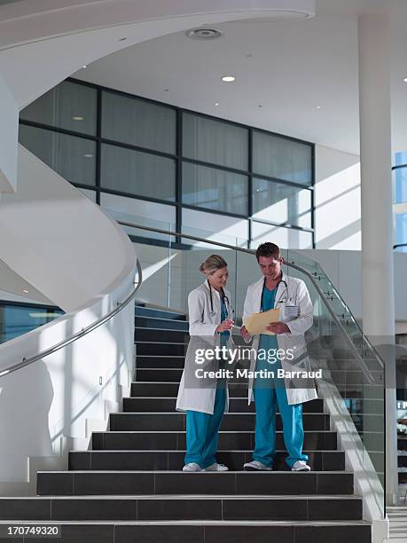 arzt zu fuß die treppe im krankenhaus - vertikal stock-fotos und bilder