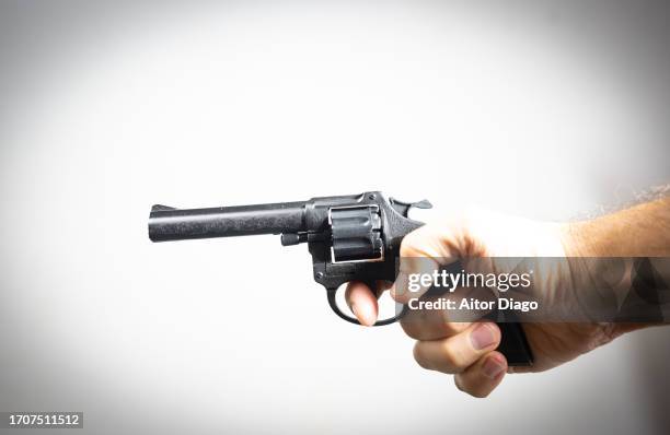 a man points a gun in one direction. - pistool handwapen stockfoto's en -beelden