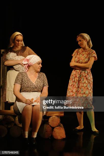 three women in rustic dresses play villagers on dimly lit stage transporting audience to heart of dramatic narrative - hamlet actor stock pictures, royalty-free photos & images