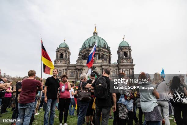 Supporters of the far right party AFD gather and hold German and Russian flags in front of the Berlin Cathedral on the 33rd anniversary of German...