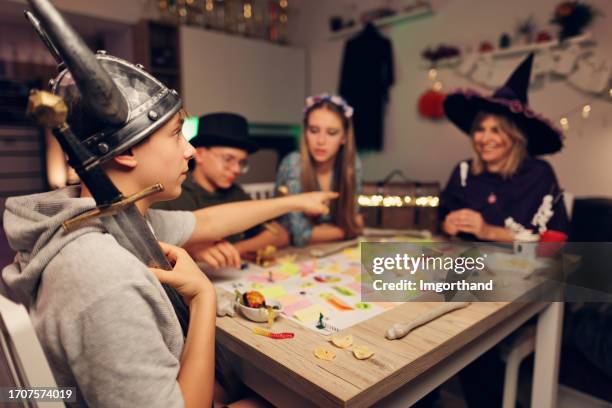 familie spielt benutzerdefiniertes brettspiel an halloween. - rollenspiel stock-fotos und bilder
