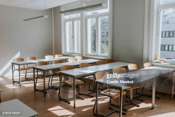 empty classroom with chairs and desks at school - silla vacía fotografías e imágenes de stock