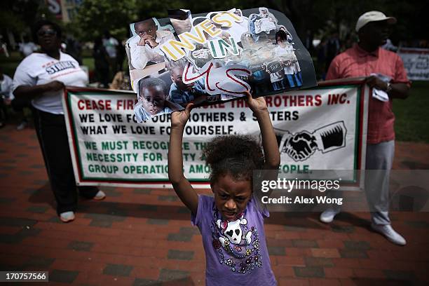 Activists hold signs during a rally June 17, 2013 at the Lafayette Park in Washington, DC. The Institute of the Black World, joined by drug and...