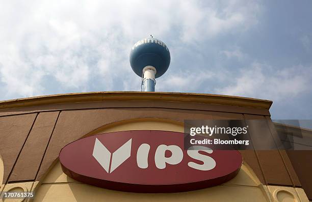 Signage for a Vips restaurant stands below to signage for Wal-Mart in the El Toreo neighborhood of Mexico City, Mexico, on Monday, June 17, 2013....