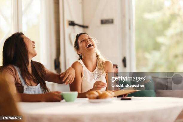 cheerful women having fun while laughing at home. - females laughing stock pictures, royalty-free photos & images