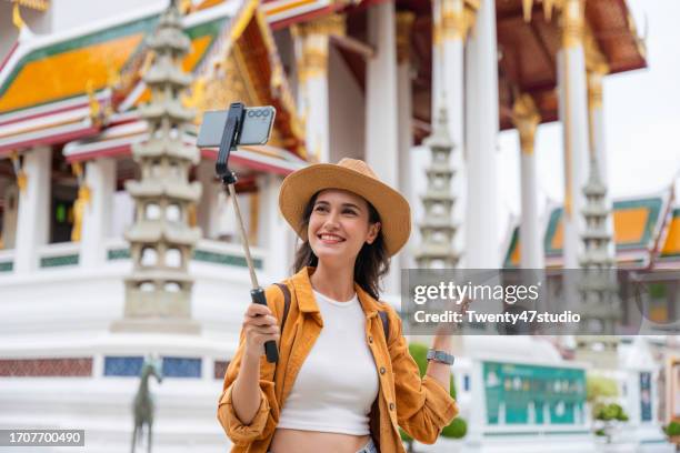a young woman vlogging while traveling in a temple in bangkok, thailand - vlogging stock pictures, royalty-free photos & images