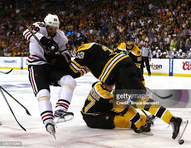 Zdeno Chara of the Boston Bruins collides with Michal Handzus of the Chicago Blackhawks in Game Three of the 2013 NHL Stanley Cup Final at TD Garden...