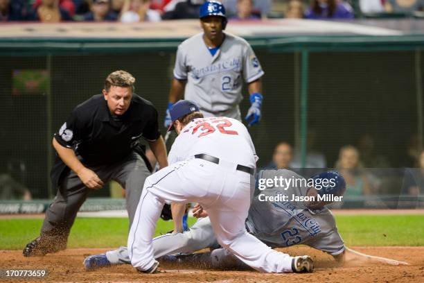 Relief pitcher Matt Albers of the Cleveland Indians tries to tag out Elliot Johnson of the Kansas City Royals who is safe at home during the ninth...