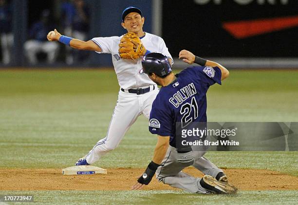 Tyler Colvin of the Colorado Rockies is forced out at second as Munenori Kawasaki of the Toronto Blue Jays throws on to first during inter-league MLB...