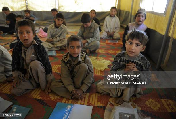 Afghan Kuchi girl boys attend a class in a tent in front of the ruins of the Darlaman Palace which was destroyed during the civil war, on the...