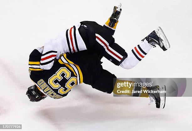 Brad Marchand of the Boston Bruins and Andrew Shaw of the Chicago Blackhawks go airborne while fighting toward the end of the third period in Game...
