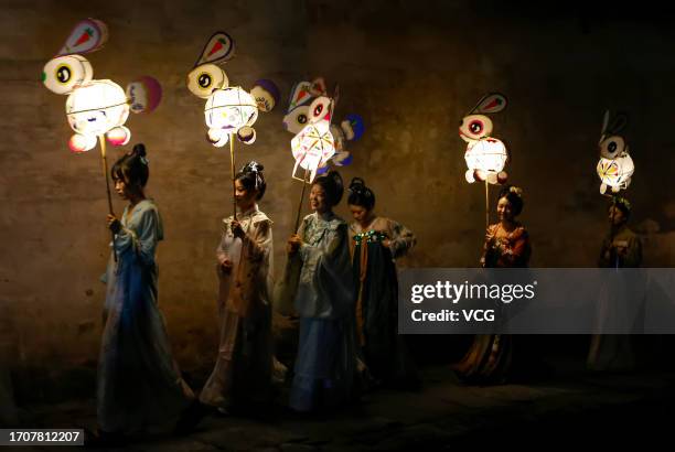 People parade with rabbit-shaped lanterns at Hongcun Village to welcome the upcoming Mid-Autumn Festival on September 28, 2023 in Huangshan City,...