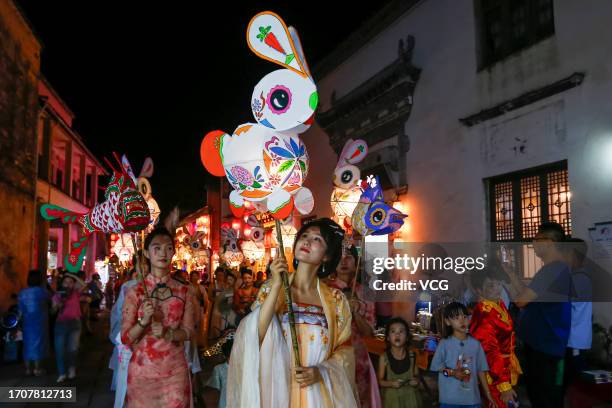 People parade with rabbit-shaped lanterns at Hongcun Village to welcome the upcoming Mid-Autumn Festival on September 28, 2023 in Huangshan City,...