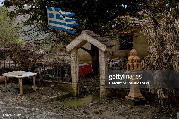 Greek flag flutters by a house in the village Vlachos which had disappeared beneath floodwaters as impact of storm Daniel on September 26, 2023 in...
