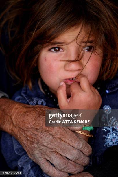 Girl from the Qashqai tribe bites her nails as she stands with her grandmother inside their tent in Eghlid in the southern Iranian province of Fars...