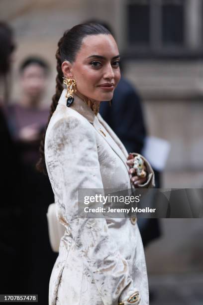 Karen Wazen is seen outside Schiaparelli show wearing golden Schiaparelli earrings and beige shiny silk Schiaparelli dress during the Womenswear...