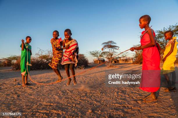 african children having fun with jumping rope in a village in northern kenya, east africa - kenyansk kultur bildbanksfoton och bilder
