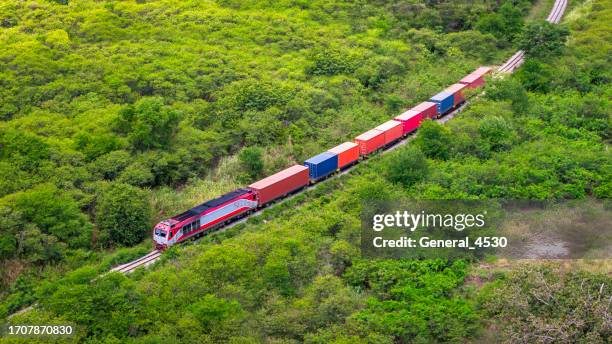 aerial view  cargo train rolls through the forest. - train vehicle stock pictures, royalty-free photos & images