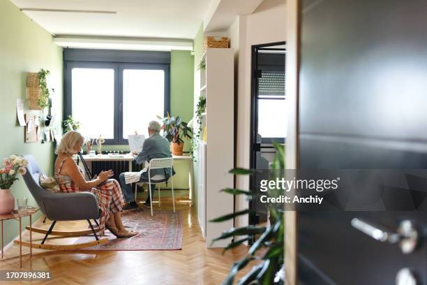 senior couple relaxing at home - house for an art lover stock pictures, royalty-free photos & images