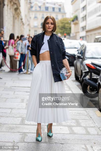 Olivia Palermo wears white skirt, heels, black jacket, blue bag Roger Vivier outside Roger Vivier on September 28, 2023 in Paris, France.