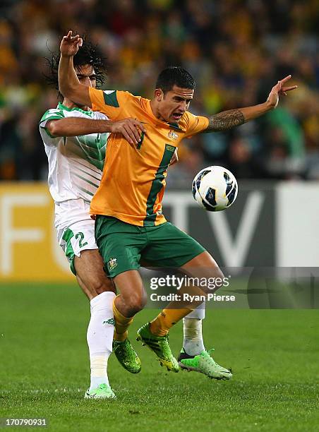 Tim Cahill of the Socceroos is tackled by Ahmad Ibrahim of Iraq during the FIFA 2014 World Cup Asian Qualifier match between the Australian Socceroos...