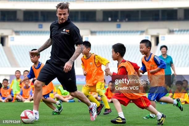 David Beckham plays football with children at at Nanjing Olympic Sports Center on June 18, 2013 in Nanjing, Jiangsu Province of China.